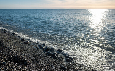 Seashore, small stones, sea wave. Marine background.