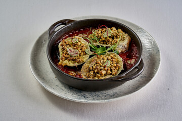 Close-up of a tender eggplant half filled with a flavorful herb and nut mixture