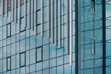 empty glass windows of a modern building with a reflection of the sky in the glass