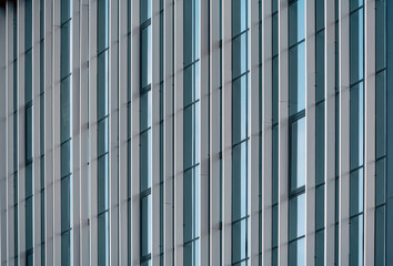 empty glass windows of a modern building with a reflection of the sky in the glass