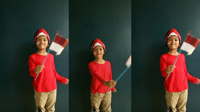 Indonesian children is holding and waving the Indonesian flag