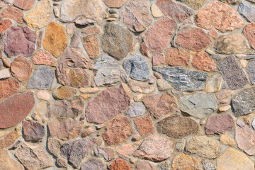 Beautiful stone wall with multi-colored stones. Stone chip.