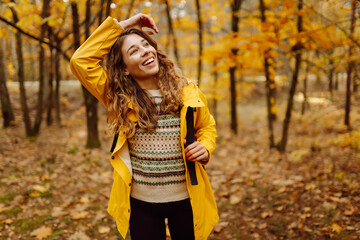 Active young woman carrying backpack enjoying beautiful autumn day outdoors. Autumn landscape. Calmness and tranquility. Travel, tourism concept.