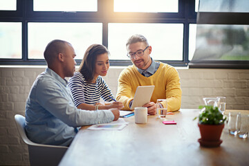 Creative, planning and business people in meeting with tablet, ideas and brainstorming together. Consulting, men and woman in conference room with digital app, teamwork or discussion at design agency