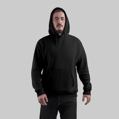 Obraz premium Вlack hoodie template with pocket, ties, sweatshirt on bearded man in black jeans, front view, isolated on background.