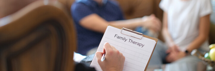 Male psychologist holding clipboard with family therapy notes sheet