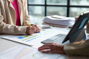 Financial analyst analysis business financial report on graph document and laptop during a discussion at corporate showing the results of their successful teamwork, business meeting concept, Marketing