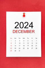 December 2024 calendar page with push pin on red background.