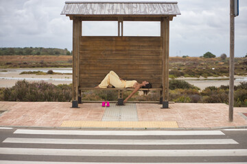 Young beautiful woman, eyes closed, in a yellow silk suit, pink heels removed, barefoot, lying down...