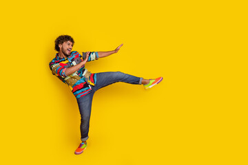 Full size photo of pretty young guy dance discotheque have fun wear trendy colorful outfit isolated on yellow color background