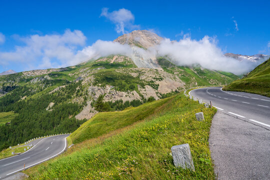 Winding alpine road Grossglockner. Beautiful mountain landscape. Clouds descend on high cliffs. Clear sunny day. Grossglockner high alpine road.  Hohe Tauern National Park. Austria