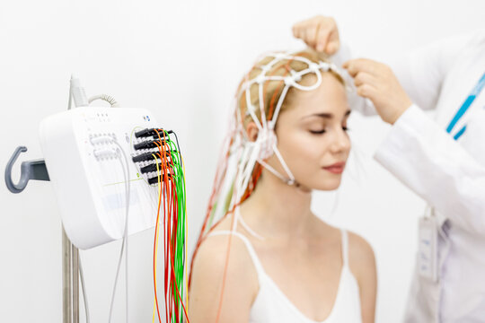 A young woman undergoes an EEG test in a modern clinic, showcasing advanced medical technology and patient care. Ideal for highlighting modern diagnostic procedures and healthcare innovations.