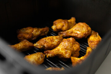 Close-up of chicken wings cooked in an air fryer in the kitchen. Juicy Chicken Wings. Close-up