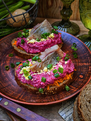 Sandwiches with herring and beetroot on a ceramic plate