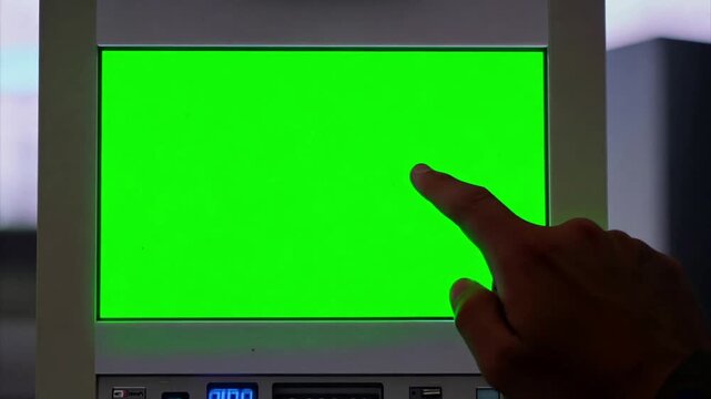 Black man's Finger pushing buttons on a touchscreen on a voting machine during a USA election where the screen is a chroma key green screen.