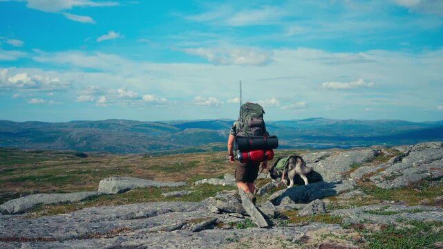 iMefjelsvatnet to Gurben in Indre Fosen, Tr&oslash;ndelag, Norway - A Hiker and His Dog Making Their Way Across the Rugged Terrain - Static Shot