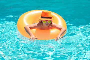 Children playing in pool. Child in swim pool on inflatable ring. Swimming pool.