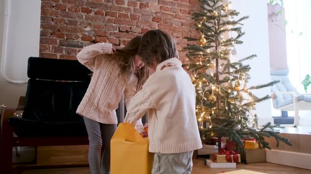 In a cozy living room decorated with twinkling lights, two excited children unwrap colorful gifts under a beautiful Christmas tree, creating a festive atmosphere filled with warmth and holiday joy