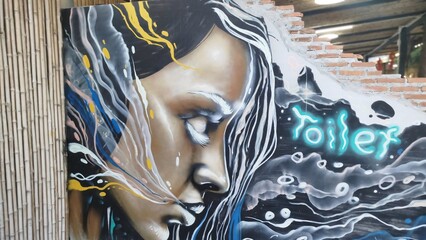 Graffiti on a wall, with a statue side on a wall.