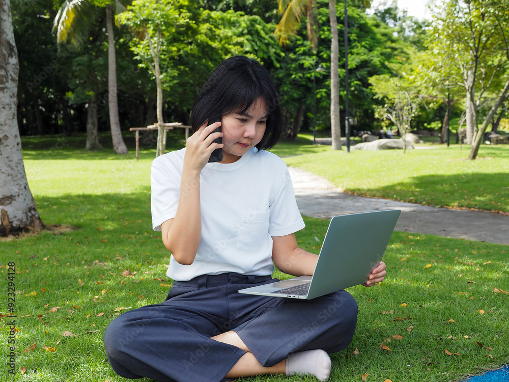 Canvas Prints young asian woman talking on the phone and working on laptop in outdoor lawn. freelance business con