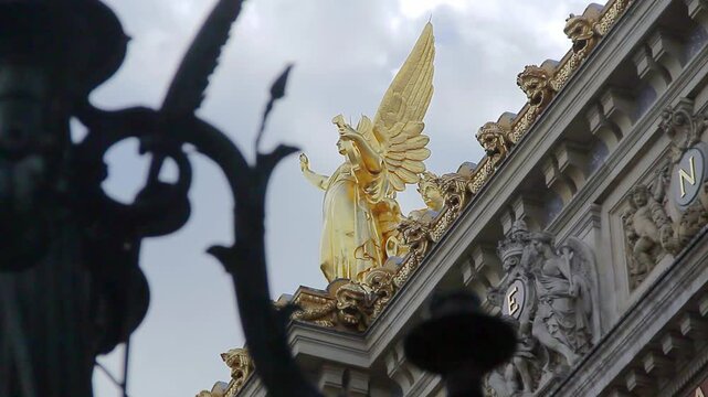 Golden sculpture presiding over a side of the facade of the Paris opera house.