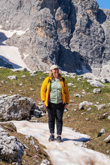 Delight and joy of an amazing mountain landscape in  middle-aged woman. Hiking brings contentment to life. Healthy, active lifestyle. Dolomite Alps, South Tyrol, Italy.