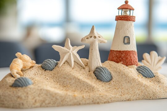 Mini lighthouse beach scene for coastal home decor and nautical themed events featuring sand seashells and bokeh lighting