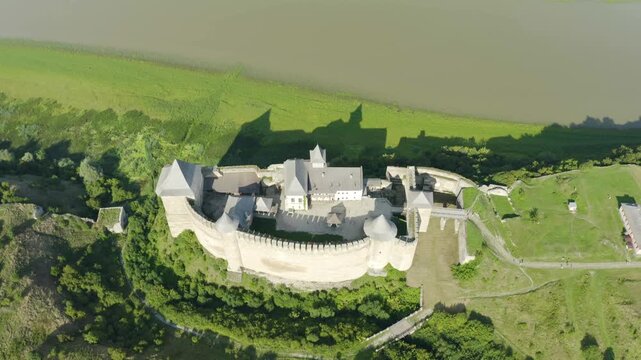Khotyn Fortress (Ukrainian: Хотинська фортеця; Romanian: Cetatea Hotinului)  fortress of the 10th-18th centuries, huge walls towers on the banks  Dniester,  drone flies by at dawn aerial photography