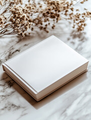 Fototapeta premium white soft cover book lying on the table, birds eye view