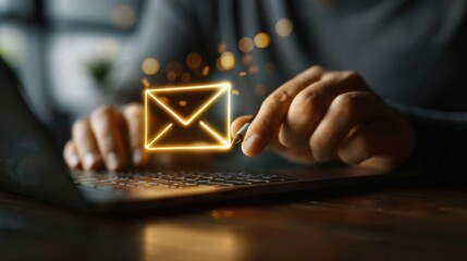 Closeup of hands typing on laptop with glowing email icon.