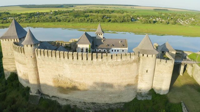 Khotyn Fortress (Ukrainian: Хотинська фортеця; Romanian: Cetatea Hotinului)  fortress of the 10th-18th centuries, huge walls towers on the banks  Dniester,  drone flies by at dawn aerial photography