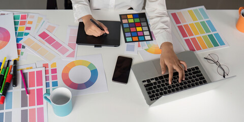 Creative Graphic Designer Working with Color Palettes and Digital Tools in Modern Office Environment