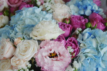 Fragment of a flower bouquet. Roses and hydrangeas - white, light blue, pink flowers. Beautiful floral background.