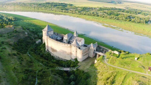 Khotyn Fortress (Ukrainian: Хотинська фортеця; Romanian: Cetatea Hotinului)  fortress of the 10th-18th centuries, huge walls towers on the banks  Dniester,  drone flies by at dawn aerial photography