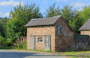 Obraz premium Ancient stone barn with barn doors and a slate roof