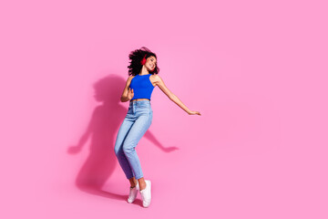 Full size photo of pretty young girl earphones dance tiptoes wear trendy blue outfit isolated on pink color background