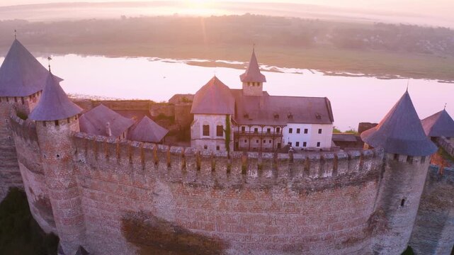 Khotyn Fortress (Ukrainian: Хотинська фортеця; Romanian: Cetatea Hotinului)  fortress of the 10th-18th centuries, huge walls towers on the banks  Dniester,  drone flies by at dawn aerial photography