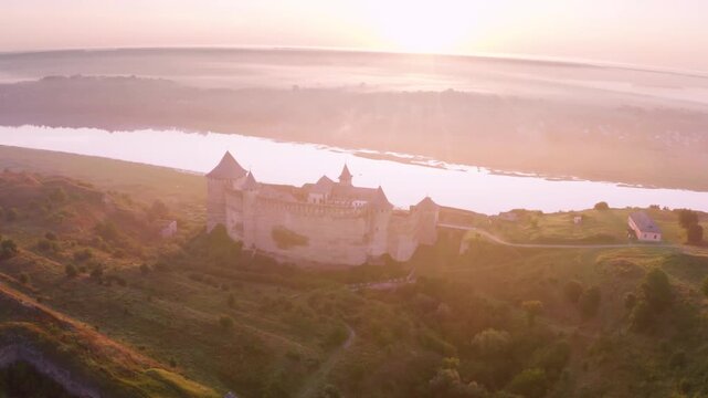 Khotyn Fortress (Ukrainian: Хотинська фортеця; Romanian: Cetatea Hotinului)  fortress of the 10th-18th centuries, huge walls towers on the banks  Dniester,  drone flies by at dawn aerial photography