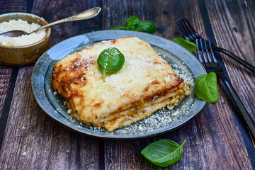  Italian Lasagna bolognese  covered with parmesan cheese  on awooden  background.