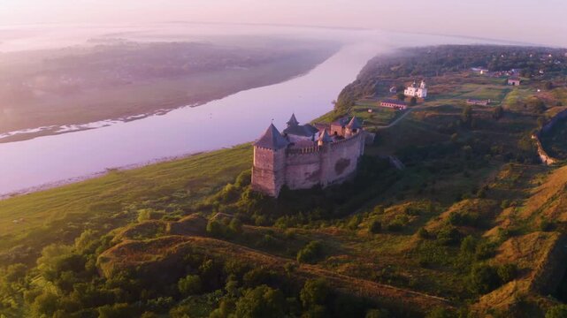 Khotyn Fortress (Ukrainian: Хотинська фортеця; Romanian: Cetatea Hotinului)  fortress of the 10th-18th centuries, huge walls towers on the banks  Dniester,  drone flies by at dawn aerial photography