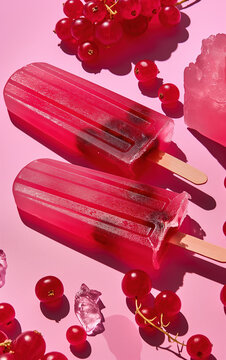 Ice cream popsicle. Fruity popsicle, ice cream with berries, fruits on color pastel background. Frozen fruit berry popsicle. Homemade ice lolly. Summer ice cream minimal fashion idea. Realistic photo