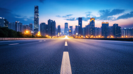 Obraz premium road leading to the city skyline at night, illuminated by blue lights, empty asphalt with white lines in front of it. Background banner concept