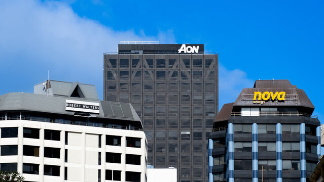 Cityscape view of office buildings with company logos for Robert Walter's, Aon, and Nova Energy in capital city of Wellington, New Zealand Aotearoa - taken on 13 August 2024