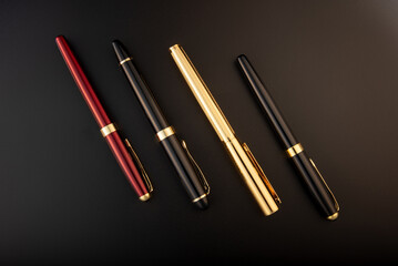 Fountain pens, beautiful fountain pens positioned on dark background, selective focus.