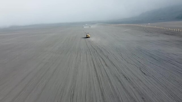 cinematic aerial jeeps crossing in sea of sand, the best landscape of mount Bromo | Video 4K drone aerial footage