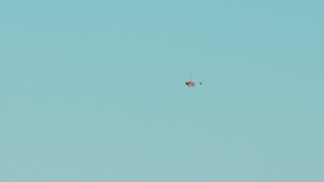 Skeet shooting bullet hits and collides with orange clay target after pull in mid air in extreme slow motion and explodes shrapnel with bullet shell flying towards camera