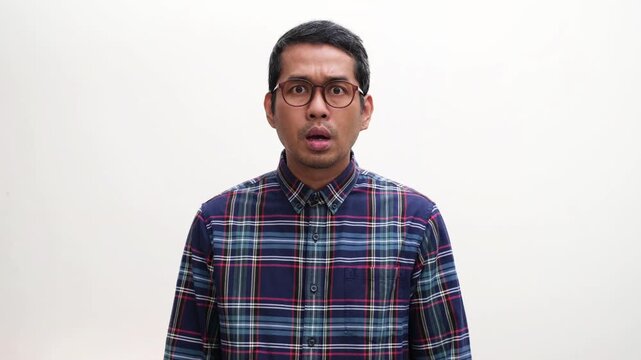 Adult Asian man looking camera showing disbelief and worried expression