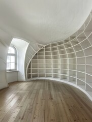 Obraz premium a room with curving, white shelfs, library, modern photography 