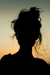 A woman with a messy bun and a serious expression