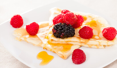 Pancakes with raspberries, blackberries and honey